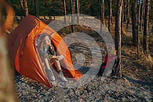Calm woman inside tent is admiring sunset