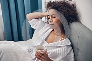 Calm woman lying in bed with her eyes shut