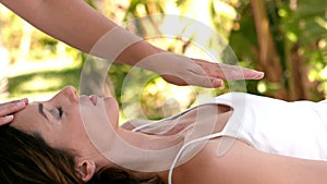 Calm woman receiving reiki treatment