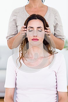 Calm woman receiving reiki treatment