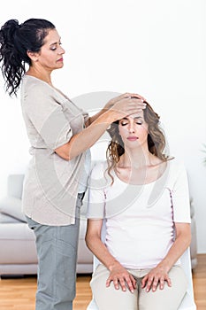 Calm woman receiving reiki treatment