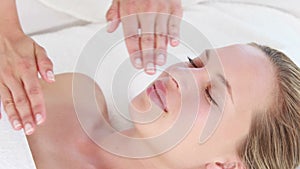 Calm woman receiving reiki treatment