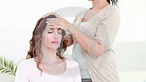 Calm woman receiving reiki treatment