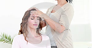 Calm woman receiving reiki treatment