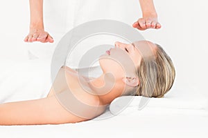 Calm woman receiving reiki treatment