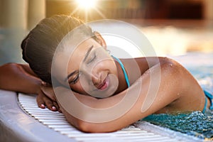 Calm woman, relax and lying with water in jacuzzi for holiday, getaway or stress relief at hotel, resort or spa. Face of