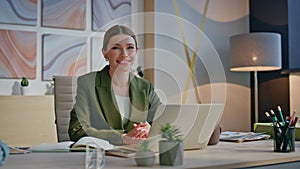 Calm woman spending break sitting laptop office closeup. Lady looking camera