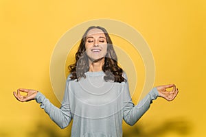 Calm young attractive woman isolated on yellow