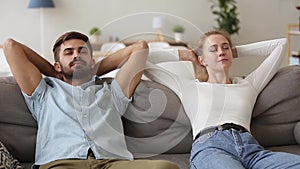 Calm young couple relaxing chilling on comfortable couch resting together