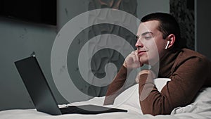 Calm young man enjoys listening chill music audio sound meditating feeling no stress at home. Student male relaxing on