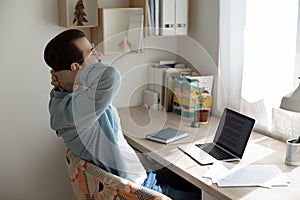 Calm young man relax in chair at home workplace