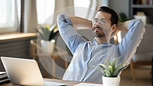 Calm young man relax in chair at home workplace