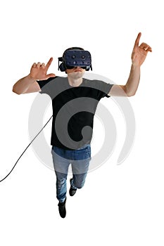 Calm young man wearing VR goggles and pointing in the air while flying on white background