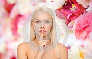 Calm young woman with finger on lips