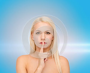 Calm young woman with finger on lips