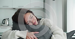 Calm young woman having healthy daytime nap dozing relaxing on couch with eyes closed women hugging her pillow, peaceful