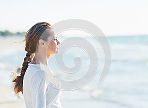 Calm young woman looking into distance at seaside