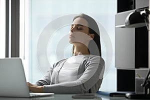 Calm young woman meditate relieve negative emotions at workplace
