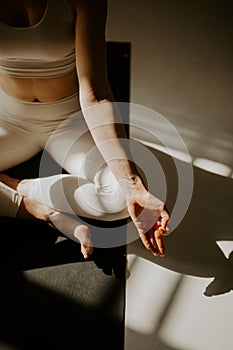 Calm young woman meditating, sitting on lotus pose at beautiful yoga studio. young attractive woman sitting in Ardha Padmasana