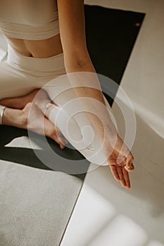 Calm young woman meditating, sitting on lotus pose at beautiful yoga studio. young attractive woman sitting in Ardha Padmasana