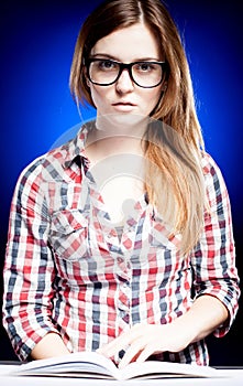 Calm young woman with nerd glasses learning diligently