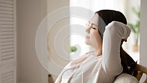 Calm young woman relax in chair taking nap