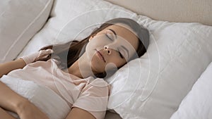 Calm young woman relax sleep in comfortable white bed