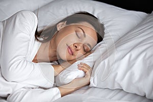 Calm young woman rest sleep in cozy bed