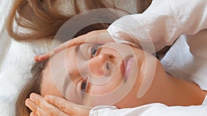 Calm young woman sleeping well in comfortable cozy bed on white soft pillows linen and waking up in the morning,insomnia
