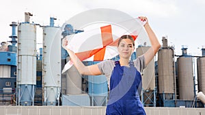 Calm young woman worker with flag of England against background of factory
