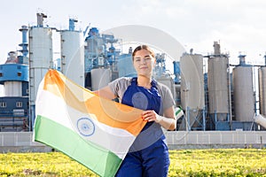 Calm young woman worker with flag of India against background of factory