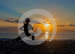 Calmness and yoga concept on the beach. Silhouette of a woman practicing yoga on the beach.