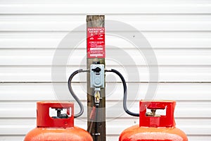Calor gas cylinder bottles refilling with hose at refill point within caravan park site photo