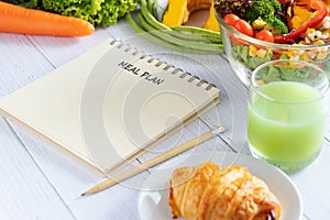 Calories control, meal plan, food diet and weight loss concept. meal plan writing on notebook planner with salad, fruit juice