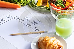 Calories control, meal plan, food diet and weight loss concept. top view of meal plan table on paper with salad, fruit juice