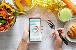 Calories counting , diet , food control and weight loss concept. woman using Calorie counter application on her smartphone photo