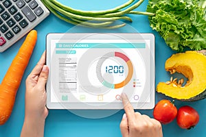 Calories counting , diet , food control and weight loss concept. woman using Calorie counter application on tablet at dining table