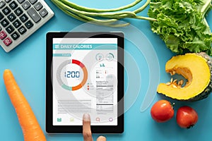 Calories counting , diet , food control and weight loss concept. woman using Calorie counter application on tablet at dining table