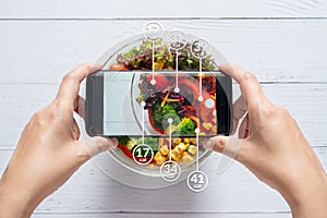 Calories counting and food control concept. woman using application on smartphone for scanning the amount of calories in the food photo