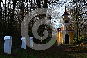 Calvary with small chapel from 1925 nd white Stations of the Cross hidden in circle of naked broadleaf trees, winter season