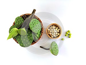 Calyxes of the lotus, lotus bud and young pod included in the basket. And white seeds in a wooden cup.