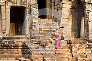 Cambodian Girl in Khmer Dress Sitting at Bayon Temple in Angkor City