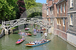 Wooden Mathematical Bridge at Queens College University with tourists and students punting on the river Cam