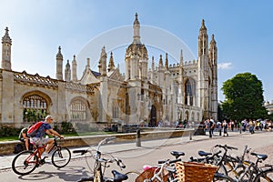 Many people near gothic King`s College Porters` Lodge chapel, many bikes