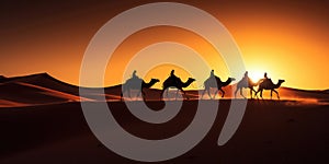 Camel caravan silhouette through the sand dunes in the Sahara Desert, Morocco