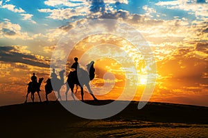 Camel caravan in silhouette at sunset at the Thar desert Jaisalmer, Rajasthan, India