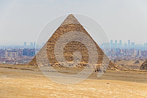 Camel caravan with tourists in front of the Great Pyramids of Giza, Egypt