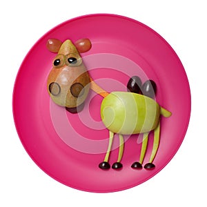 Happy camel made with fruits on pink plate