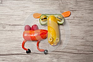 Funny camel made of vegetables on wooden background