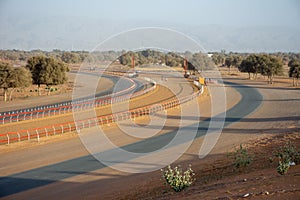 Camel Racing is an Arabian Gulf tradition. This camel race track shows the curve of the sandy track in the evening sun.